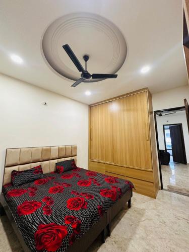a bedroom with a bed with red roses on it at Shivam home in Kharar