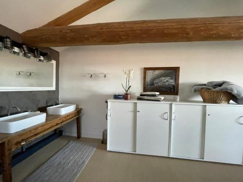 ein Badezimmer mit zwei Waschbecken und einer Holztheke in der Unterkunft La Grange aux hirondelles - appartement complet et indépendant in Commelle-Vernay