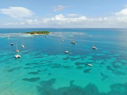 eine Insel im Ozean mit Booten im Wasser in der Unterkunft Emeraude Bay, Magnifique T3 Vue Mer proche de la plage in Le Gosier