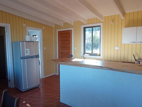 a kitchen with a refrigerator and a counter top at Cabaña Curanipe Playa in Curanipe