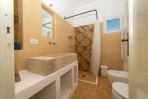 een badkamer met een grote wastafel en een toilet bij I Farasuli in Marina Porto