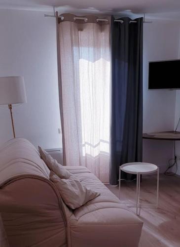 un salon avec un canapé et une fenêtre dans l'établissement Studio proche Gare, à Nîmes