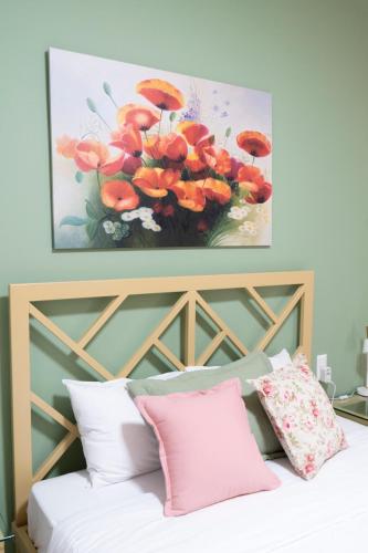 a painting of a vase of flowers above a bed at Anastasia's Luxury House in Kavala
