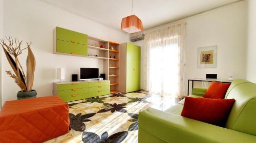 ein Wohnzimmer mit grünen und orangefarbenen Möbeln in der Unterkunft Casa Iolanda in Riposto