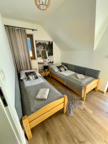 a bedroom with two beds and a couch at Chata Stylchyn in Kluszkowce