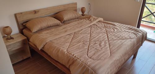 1 cama grande en un dormitorio con cabecero de madera en Care Rock Guesthouse, en Phumĭ Chroŭy Svay