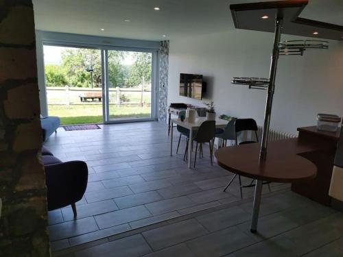 un salon avec des tables et des chaises et une grande fenêtre dans l'établissement Gîte de tourisme, 4/6 personnes, à Mondigny