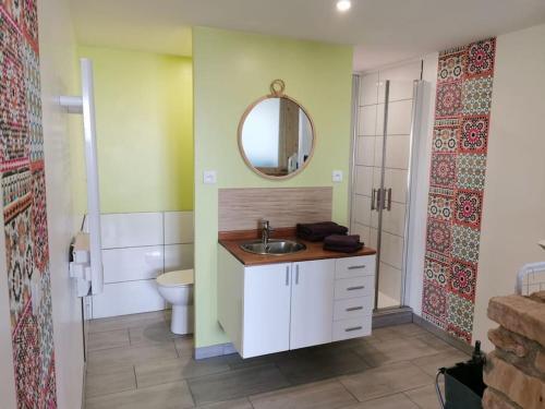 une salle de bain avec un lavabo, des toilettes et un miroir dans l'établissement Gîte de tourisme, 4/6 personnes, à Mondigny