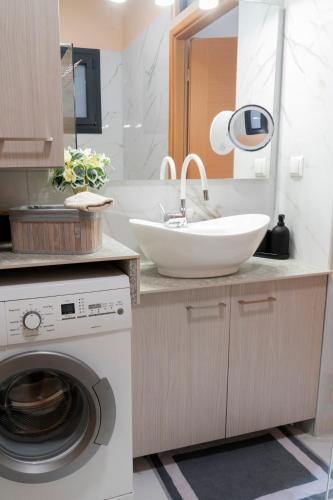 a bathroom with a sink and a washing machine at Anastasia's Luxury House in Kavala