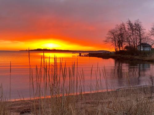 een zonsondergang boven een waterlichaam met zonsondergang bij Lys nyoppusset leilighet in Tønsberg