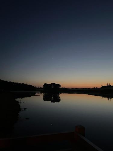 a view of a lake at night with the sun setting at East Learmouth Lakeside Lodges in Cornhill-on-tweed