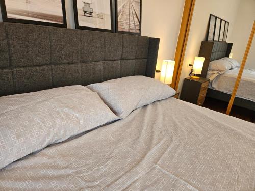 a bed in a bedroom with two pillows on it at Los Castelos by Urraca Suites Viveiro in Viveiro