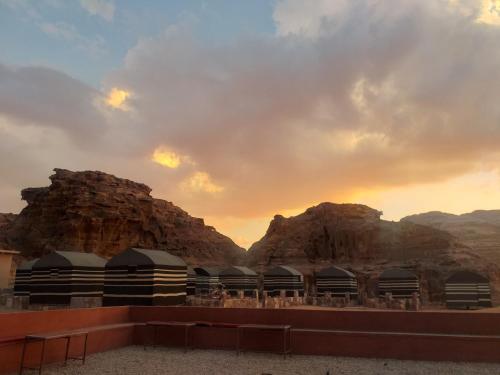 a group of buildings with mountains in the background at Mohammed Wadi Rum Camp in Wadi Rum