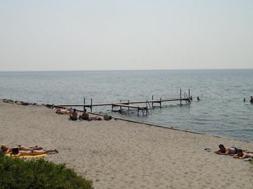 a group of people laying on the beach at Nysted Strand Camping & Cottages in Nysted