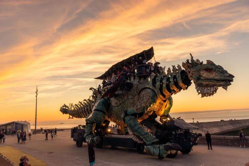 une statue de dragon sur la plage au coucher du soleil dans l'établissement Studio Le Mer'Veilleux, à Calais