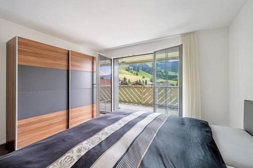 um quarto com uma cama grande e uma janela grande em helle moderne 3,5-Zimmer-Wohnung 84m2 em Oberiberg