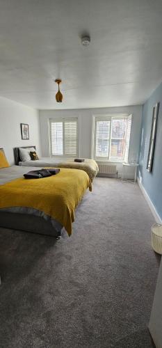 a bedroom with a large bed with a yellow blanket at Highgate Duplex Guest Flat in London