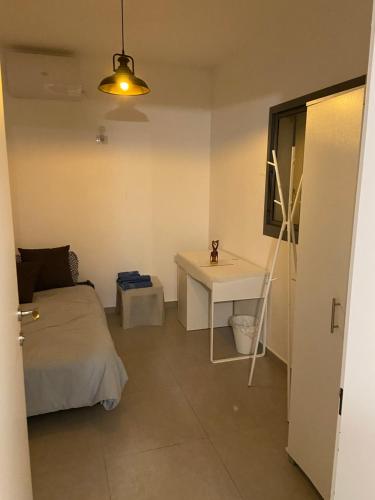 Schlafzimmer mit einem Bett, einem Tisch und einem Schreibtisch in der Unterkunft דירת גג ים עכו חיפה נוף מרהיב in Akkon