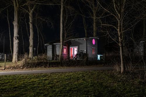 a small house with pink lights on it at night at Nysted Strand Camping & Cottages in Nysted
