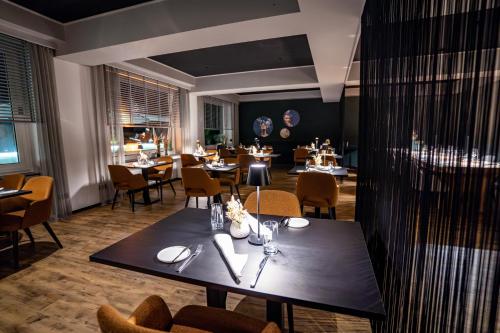a restaurant with a black table and chairs and tables and tablesktop at Landgasthof Eiserner Ritter in Boppard