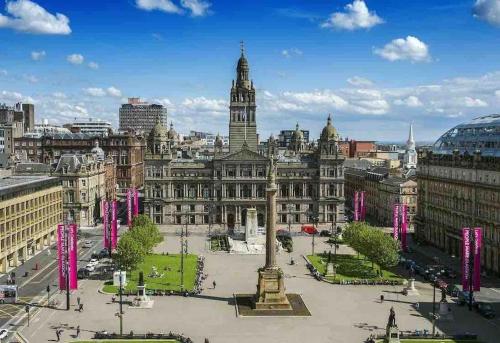 a city with a large building with a clock tower at The Naburn - 3 Bed House with Free Parking & Close to City Centre in Glasgow