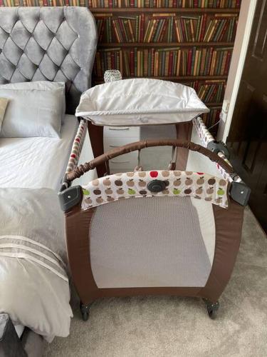 a baseball bat holder sitting next to a bed at The Naburn - 3 Bed House with Free Parking & Close to City Centre in Glasgow