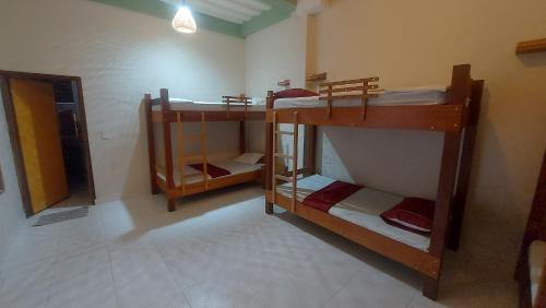 Habitación con 3 literas en una habitación en La Jangada Hostel & Tours, en Leticia