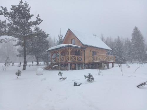 a large wooden cabin with snow on the ground at Markowa Chata in Cisna
