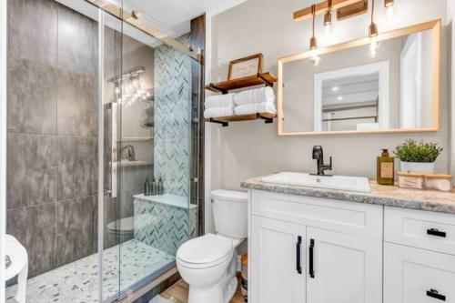 een badkamer met een douche, een toilet en een wastafel bij Lux Winter Getaway with Hot Tub, Sauna, EV charger in Haliburton