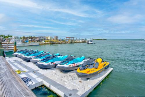 a row of boats parked on a dock in the water at Captain Pip's Marina & Hideaway in Marathon