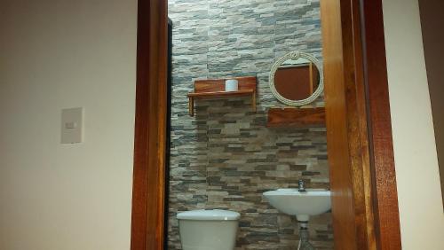 a bathroom with a sink and a toilet and a mirror at La Jangada Hostel & Tours in Leticia
