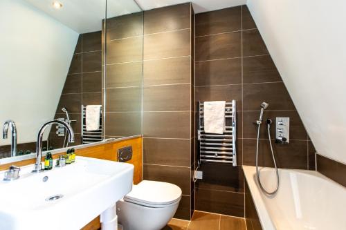 a bathroom with a sink and a toilet and a tub at Contemporary Central London apartments in London
