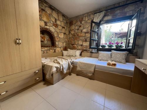 sypialnia z łóżkiem i oknem w obiekcie Boutique Stone Houses w mieście Psakoudia