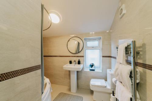 ein Bad mit einem Waschbecken und einem Spiegel in der Unterkunft Stunning spacious, Family, Contractor Fast WiFi, Sky TV, close to City Centre in Birmingham
