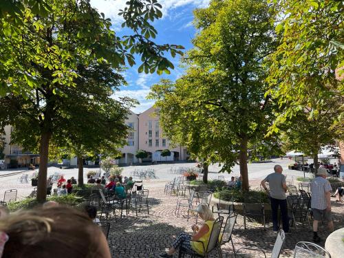 a group of people sitting in chairs in a park at Wunderschönes Apartment mit Bademantelgang zur Wohlfühltherme in Bad Griesbach