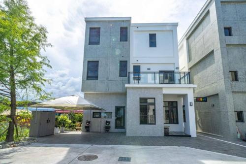 a large white building with a patio in front of it at Wei Yu's Home Villa in Dongshan