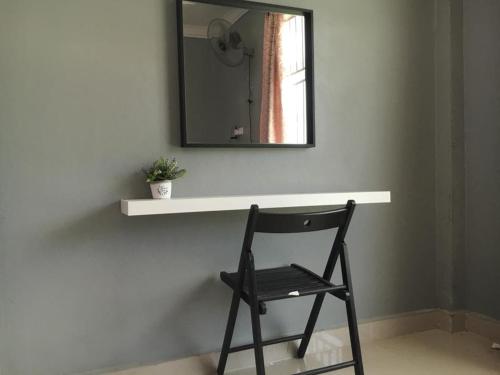 a chair sitting in front of a counter with a mirror at D' Bunga Hotel Bukit Bunga Bilik Family Deluxe in Batu Karang