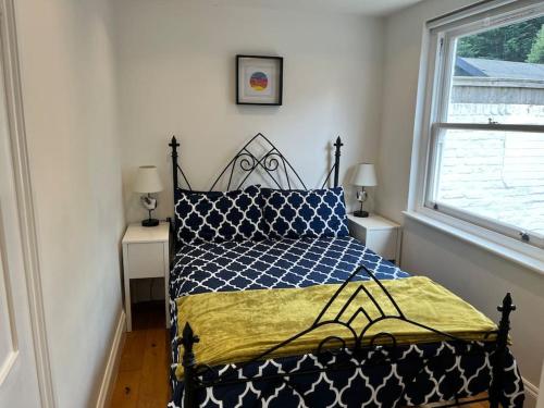 1 dormitorio con 1 cama con edredón azul y amarillo en Lovely Annexe near Surbiton/Kingston, SW London, en Chessington
