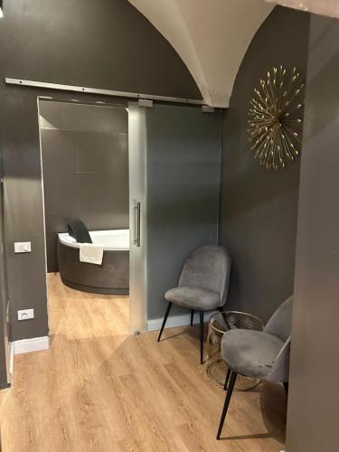 una habitación con una cama y dos sillas y un espejo en Beb c’est lavis, en Lavis