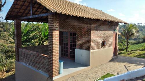 a small brick house with a roof at CASA NO CONDOMÍNIO CAMINHO DA SERRA in Bananeiras