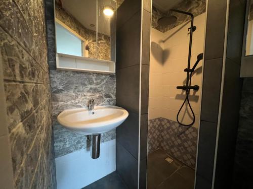 a bathroom with a sink and a shower at Beach Apartment in Vlissingen