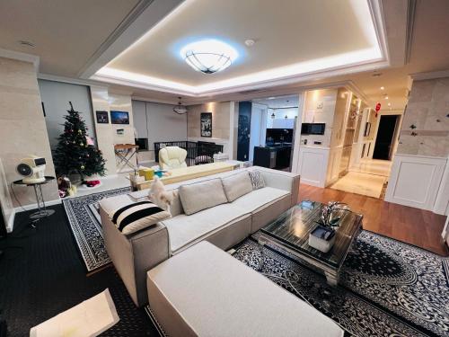 a living room with a white couch and a christmas tree at Zenith residence in Ulsan
