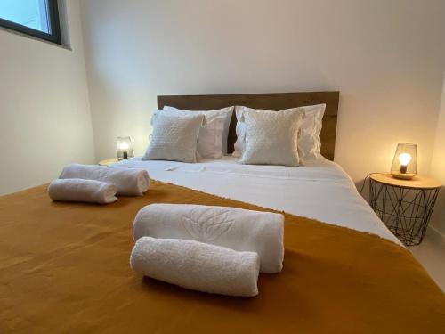 a bedroom with a large bed with towels on it at Casa da Avenida VILLA INN in Braga