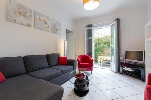 un salon avec un canapé et une télévision dans l'établissement appartement RDC, à Antibes