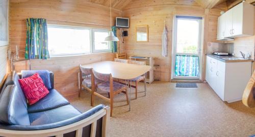 a kitchen and dining room with a table and chairs at Nysted Strand Camping & Cottages in Nysted
