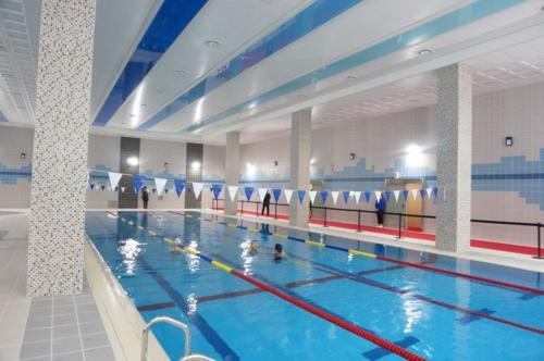 a large indoor swimming pool with people in it at Zenith residence in Ulsan