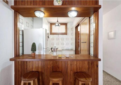 a kitchen with a counter with stools and a refrigerator at Costa Azul apartamento con vista in Candelaria