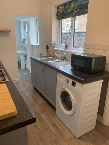 a kitchen with a washing machine and a sink at SkylinesAirbnb in Stoke on Trent