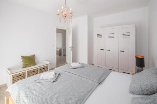 Habitación blanca con cama y lámpara de araña. en Villa More Mio, en Poreč