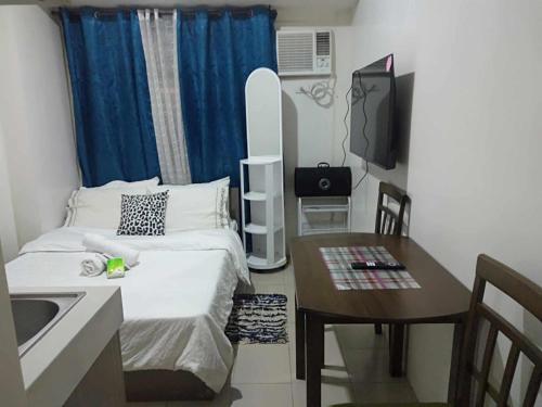a small room with a bed and a table and a television at Pierrecondotel in Manila
